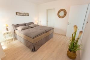 a bedroom with a large bed in a room at Komfort-Ferienwohnung Waterkant by Meer-Ferienwohnungen in Olpenitz