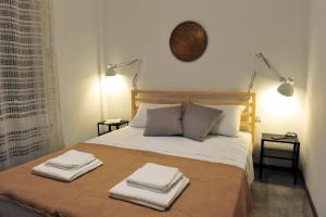 a bedroom with a bed with two towels on it at apartment 99 in Néa Péramos