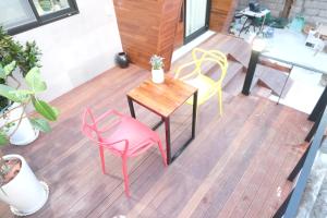 een terras met 2 stoelen en een tafel en stoelen bij HAH Guesthouse in Seoul