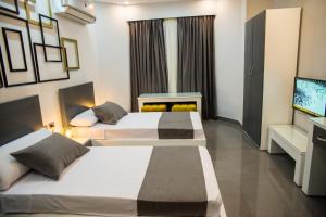 een hotelkamer met 2 bedden en een televisie bij Egyptian Night Hostel in Caïro