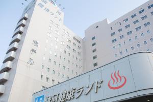 un edificio con un cartello davanti di Kur and Hotel Suruga a Shizuoka