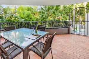 a patio with a table and chairs on a balcony at Naousa II in Noosa Heads