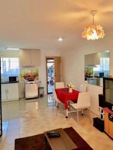 a kitchen and living room with a red table and chairs at JJJGM PLACE @ ALEX HILLS in Ormiston