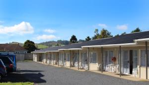a row of houses with chairs in a parking lot at Twin Coast Adventures in Kaikohe
