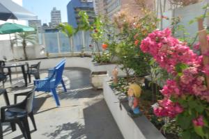 einen Balkon mit einem Tisch, Stühlen und Blumen in der Unterkunft Hotel Calstar in São Paulo