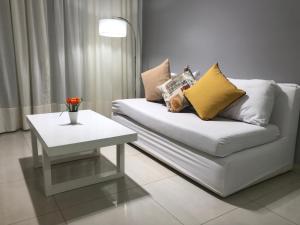 a living room with a white couch and a table at Edificio Celedonio Gutiérrez 651 in San Miguel de Tucumán