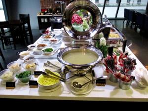 a buffet of food on a table with a mirror at Ascott Sentral Kuala Lumpur in Kuala Lumpur