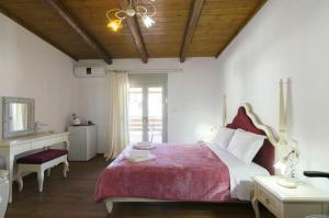 sypialnia z dużym łóżkiem i czerwonym kocem w obiekcie Zaros w mieście Zaros