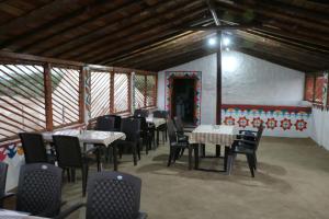 a restaurant with tables and chairs in a room at Banni Village Stay in Bherandiāla