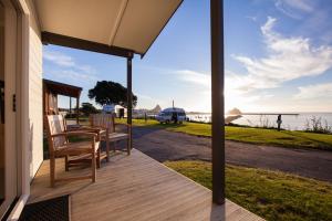 - une terrasse couverte avec des chaises et une vue sur l'eau dans l'établissement Belt Road Seaside Holiday Park, à New Plymouth