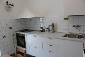 a white kitchen with a sink and a stove at Casa Orchidea in Sestri Levante