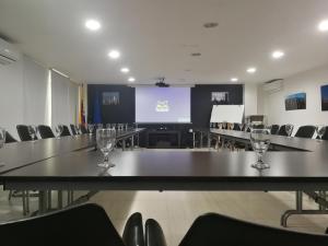 a conference room with tables and chairs and a screen at Aqua Granada Hotel in Cali