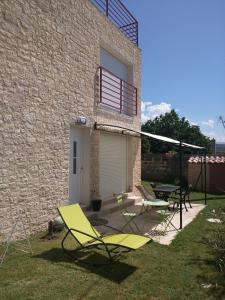 a patio with chairs and a table and a building at Le Mas de la Tortue (Plain Pied) in Caromb