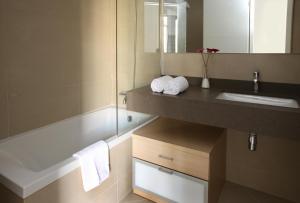 a bathroom with a sink and a bath tub at MH Apartments Suites in Barcelona
