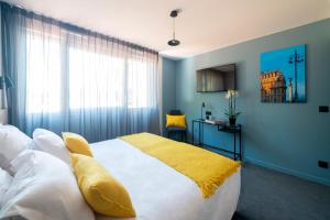 - une chambre avec un grand lit et une couverture jaune dans l'établissement Hotel Enight, à Gradignan