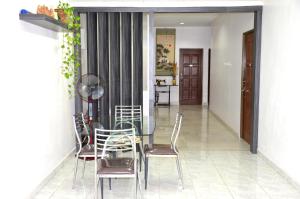 a dining room with a glass table and chairs at Homestay Klebang Ipoh in Ipoh