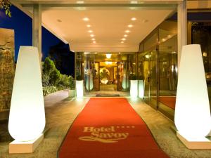vestíbulo del hotel con alfombra roja frente a un edificio en Hotel Savoy, en Pesaro