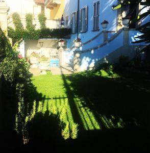 l'ombra di una casa sull'erba in un giardino di Villa Annamaria B&B a Domaso