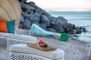 a slice of watermelon in a bowl on a chair on the beach at U Boutique Kinneret by the Sea of Galilee in Tiberias