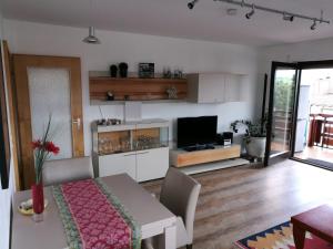 ein Wohnzimmer mit einem Esstisch und einem TV in der Unterkunft Ferienwohnung "Percy" in Sonthofen