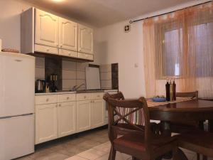 a kitchen with a table and a white refrigerator at Apartmani Josipa in Šibenik