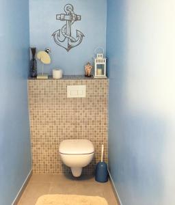 a bathroom with a toilet and an anchor on the wall at Apartments Pirka in Pirovac