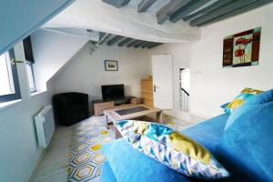 ルーアンにあるCoeur de Rouenの青いベッドとリビングルームが備わる客室です。