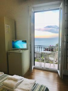 a bedroom with a view of the ocean from a balcony at Camera Vista Mare Sunrise-Top Panorama in Sirolo in Sirolo