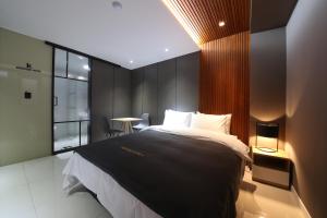 a bedroom with a large bed and a large window at Hotel K in Jeonju