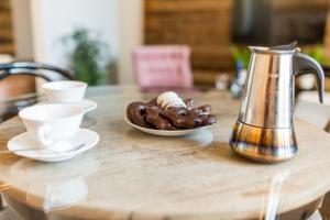 a table with a plate of doughnuts and a tea kettle at Way2Stay Apartment with parking in Toruń