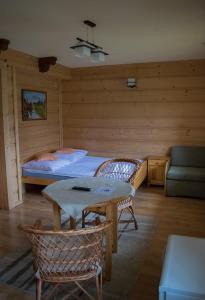 コシチェリスコにあるBacowa Chataのベッドルーム1室(ベッド1台、テーブル、ソファ付)
