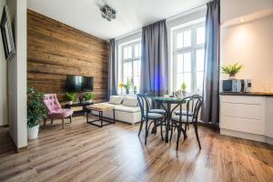 a living room with a table and chairs and a couch at Way2Stay Apartment with parking in Toruń