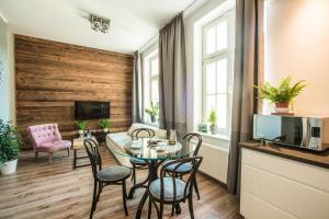 a living room with a table and chairs and a tv at Way2Stay Apartment with parking in Toruń +22 photos
