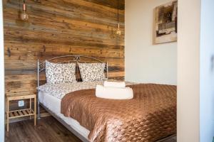 a bedroom with a bed with a wooden wall at Way2Stay Apartment with parking in Toruń