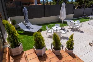 un patio con mesa, sillas y sombrilla en Hotel Marivella, en Calatayud