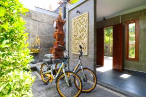 dos bicicletas estacionadas frente a una casa en Gempita House Bali en Legian