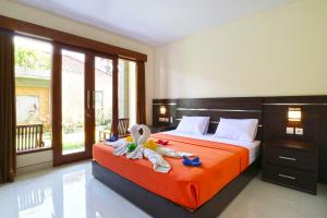 um quarto com uma cama com um bicho de peluche em Gempita House Bali em Legian