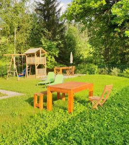 einen Picknicktisch und Stühle in einem Hof mit Spielplatz in der Unterkunft Ferienhaus Mountain View in Spital am Pyhrn