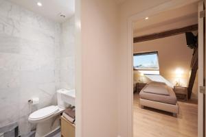 un bagno con un water e un letto in una stanza di Hotel Royal Astrid a Aalst