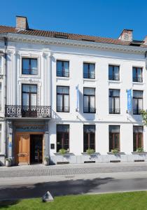 a white building with a brown door and windows at Hotel Royal Astrid in Aalst