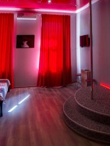 sala de estar con cortinas rojas y mesa en Re-Ka Luxury Apartments, en Odessa