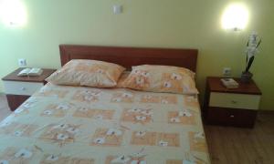 a bedroom with a bed with two night stands and two tables at Apartments Mara in Drage