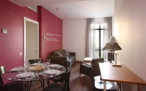 a dining room with a table and a living room at MH Apartments Suites in Barcelona