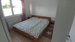 een kleine slaapkamer met een bed en een raam bij plattedijk 25-47 in Lemmer