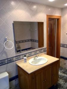 a bathroom with a sink and a mirror at Posada Adela in Santillana del Mar