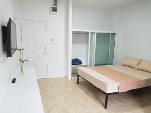 ein Schlafzimmer mit einem Bett und einem TV. in der Unterkunft Prukpibul Apartment in Bangkok