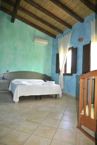 1 dormitorio con 1 cama en una pared azul en Agriturismo Rubinu, en Galtellì