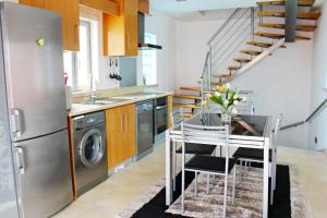 a kitchen with a stainless steel refrigerator and a table at Apartamento Beltia in Nazaré