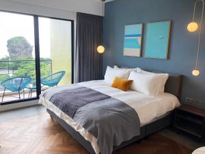 1 dormitorio con 1 cama grande y balcón en Hotel Everyday Life, en Eluan