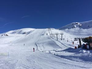 un grupo de personas esquiando por una pista de esquí cubierta de nieve en Hotel Banchetta en Sestriere